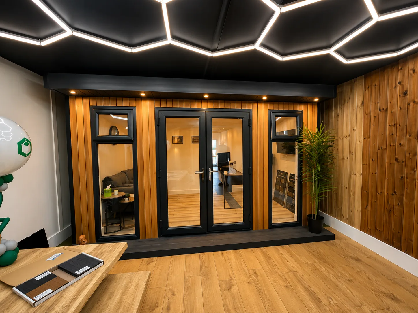 Inside a showroom building: oak flooring, timber lining and hex lighting overhead